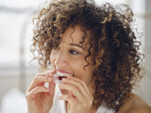 Invisalign® clear aligners being put into mouth